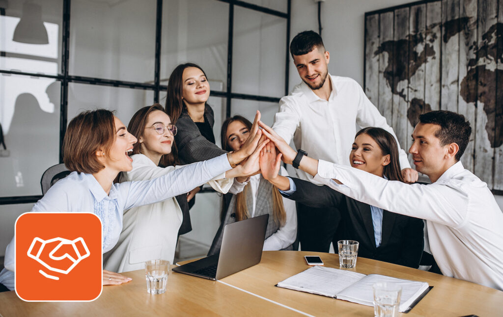 A team of seven people celebrating in office