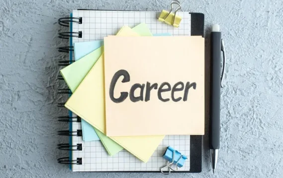 Notebook with grid pattern, pastel sticky notes, and a pen, featuring a prominently displayed note labeled 'Career.'